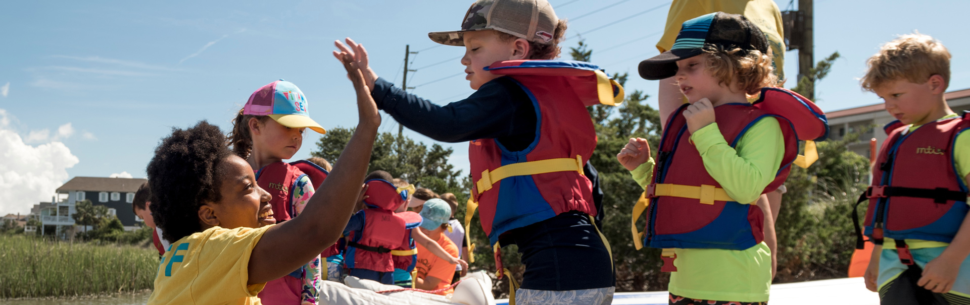 Youth high fiving teacher during a kayak trip