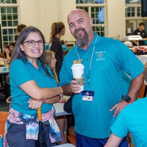 Two staff smiling at an event on campus.