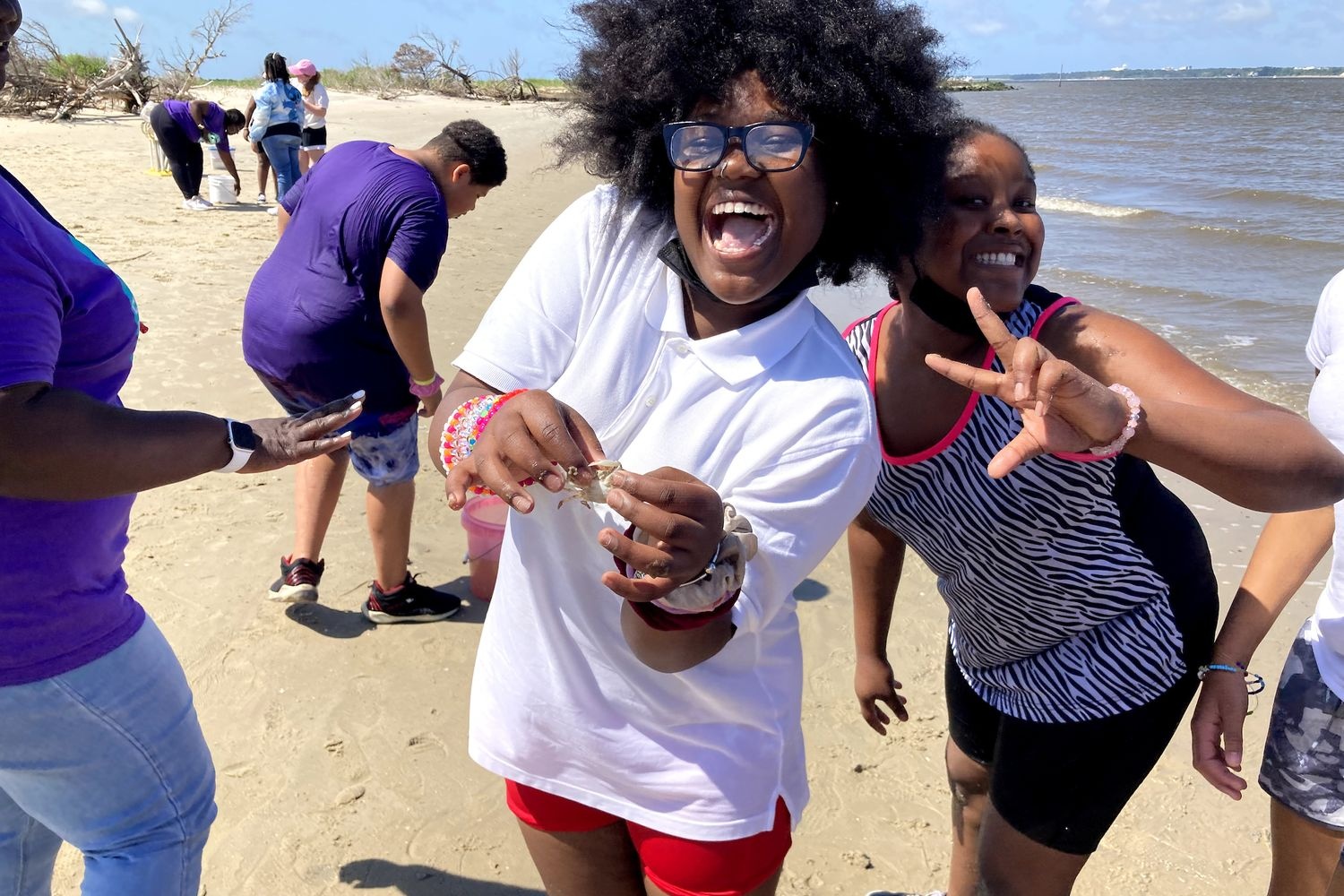 two DC Virgo students holding a crab