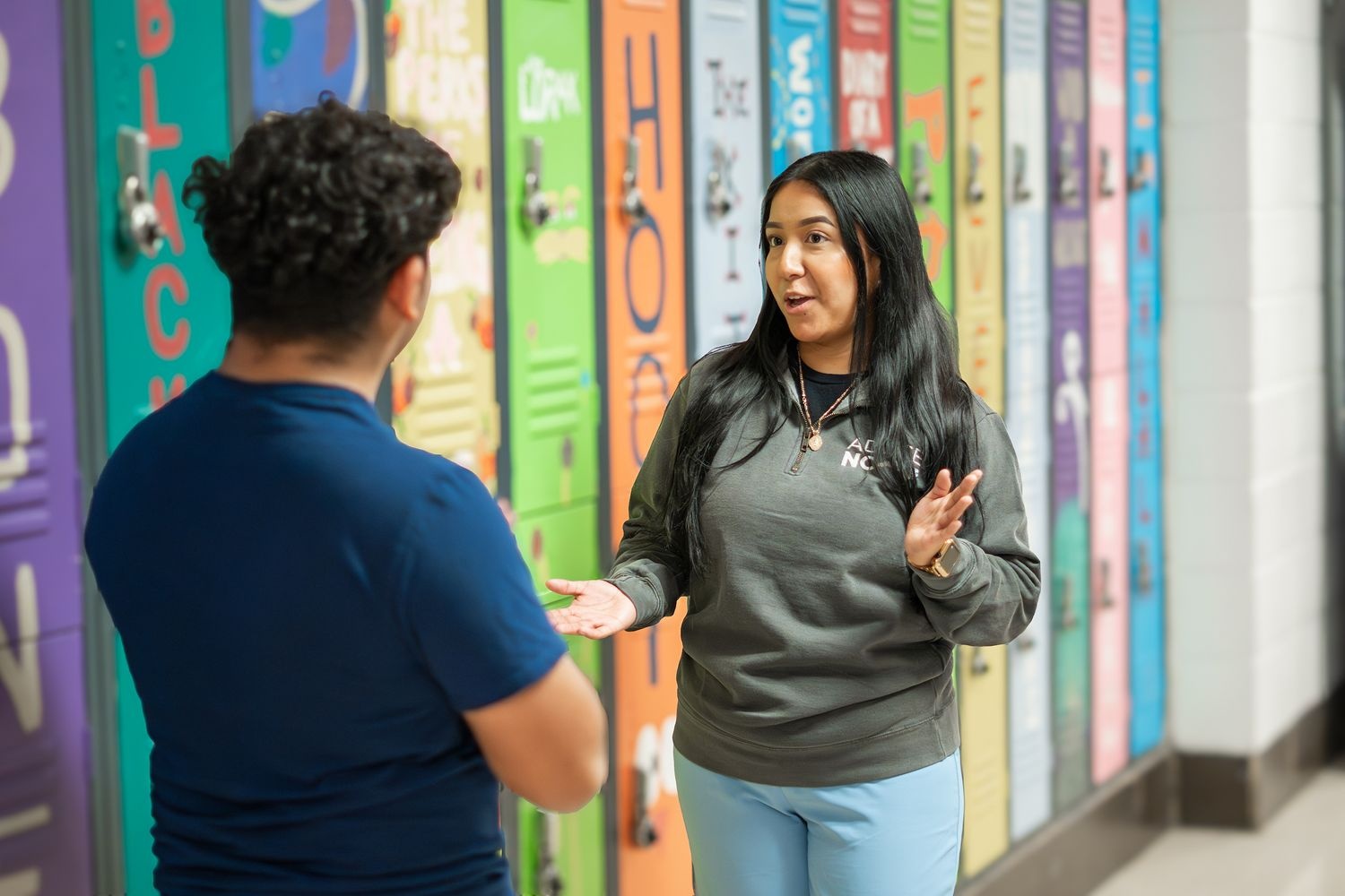 Next Step Adviser talking with a student in the high school hallway