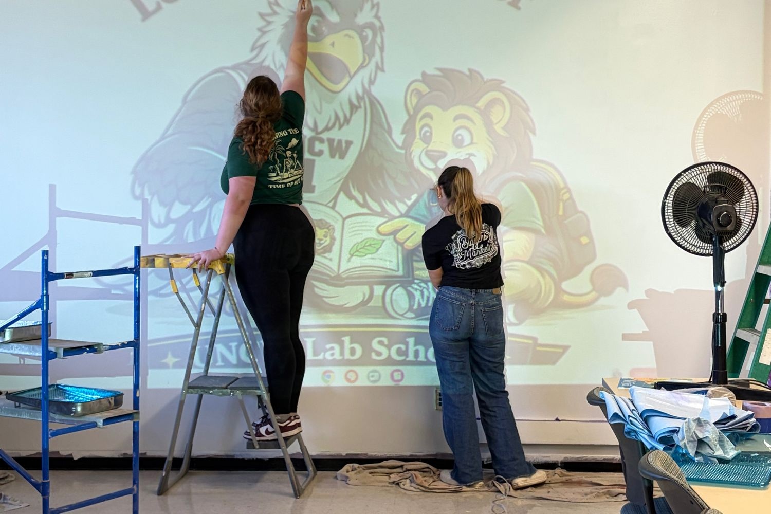 Maddi Hilton and Kendra Sheets paint the mural at D.C. Virgo