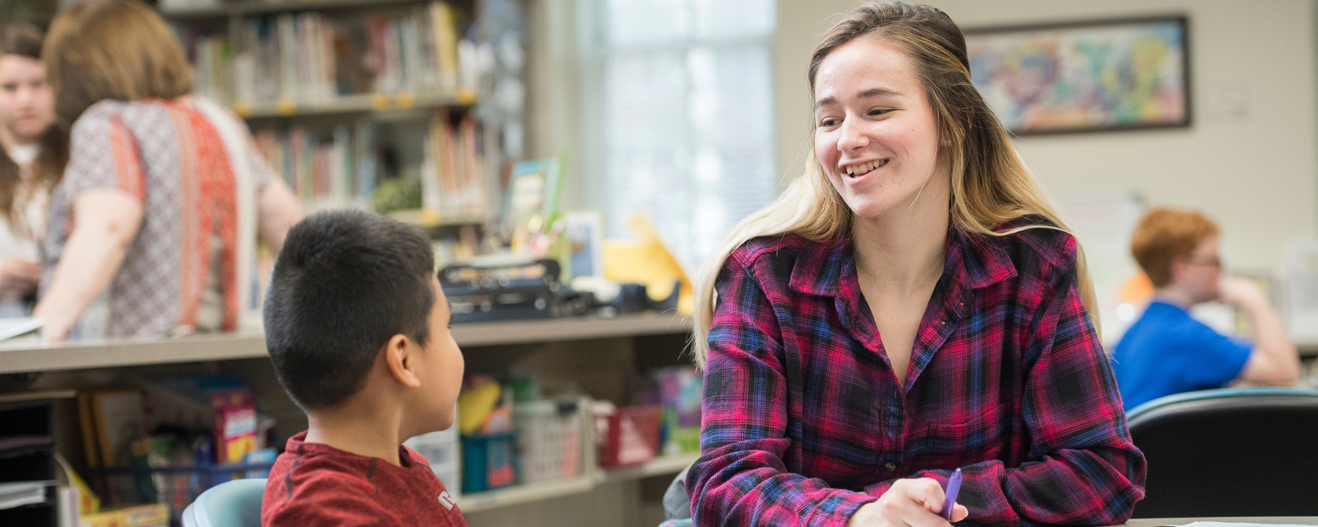 Student talks to youth in a classroom