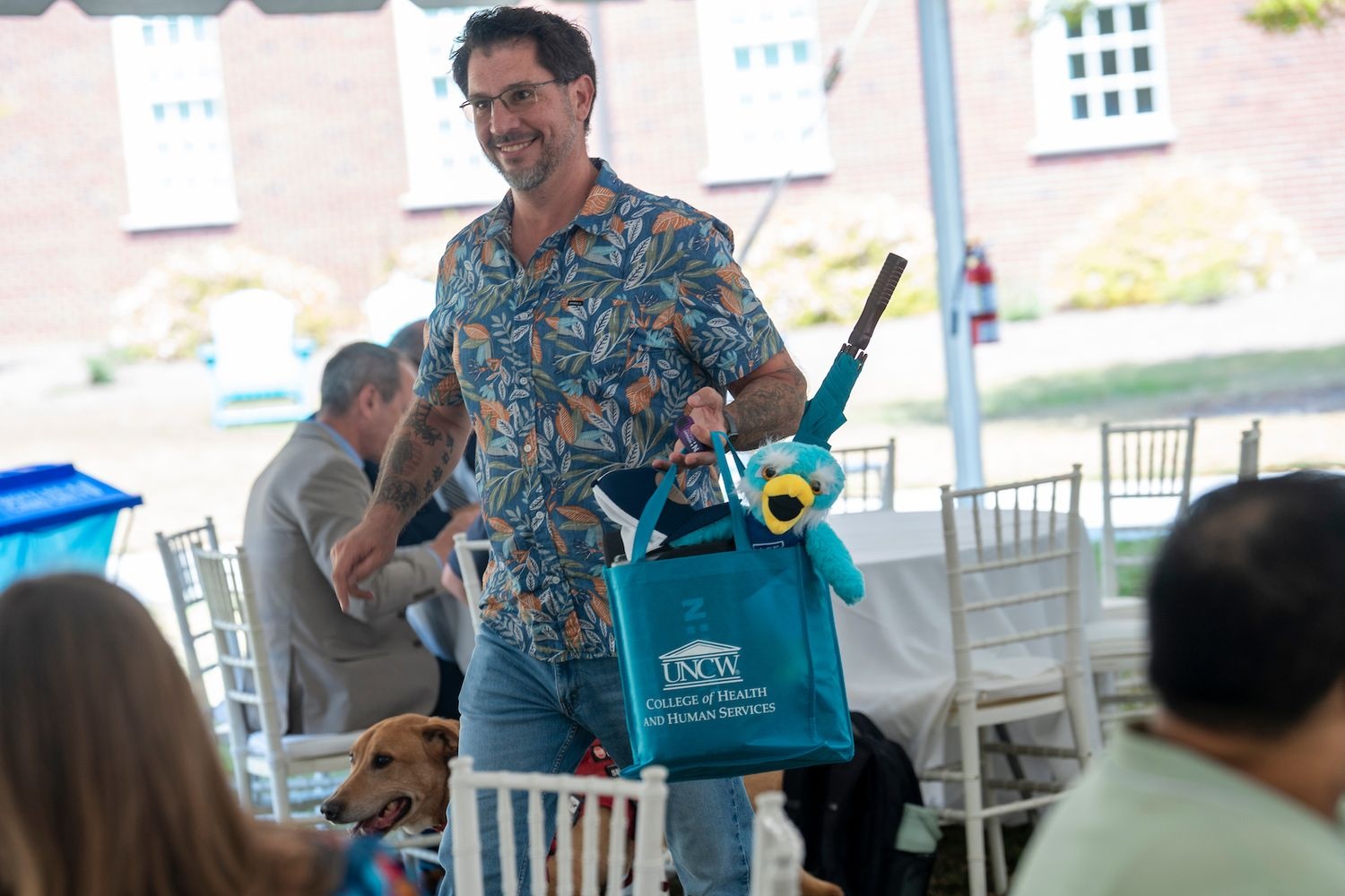 A student and his service dog walk away with a bag full of with prizes from the Health and Human Services Week end of the week celebration.