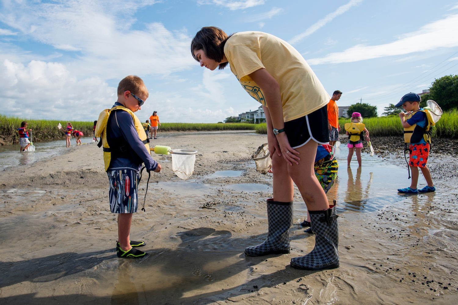 MarineQuest instructor talks to a young student on the marsh