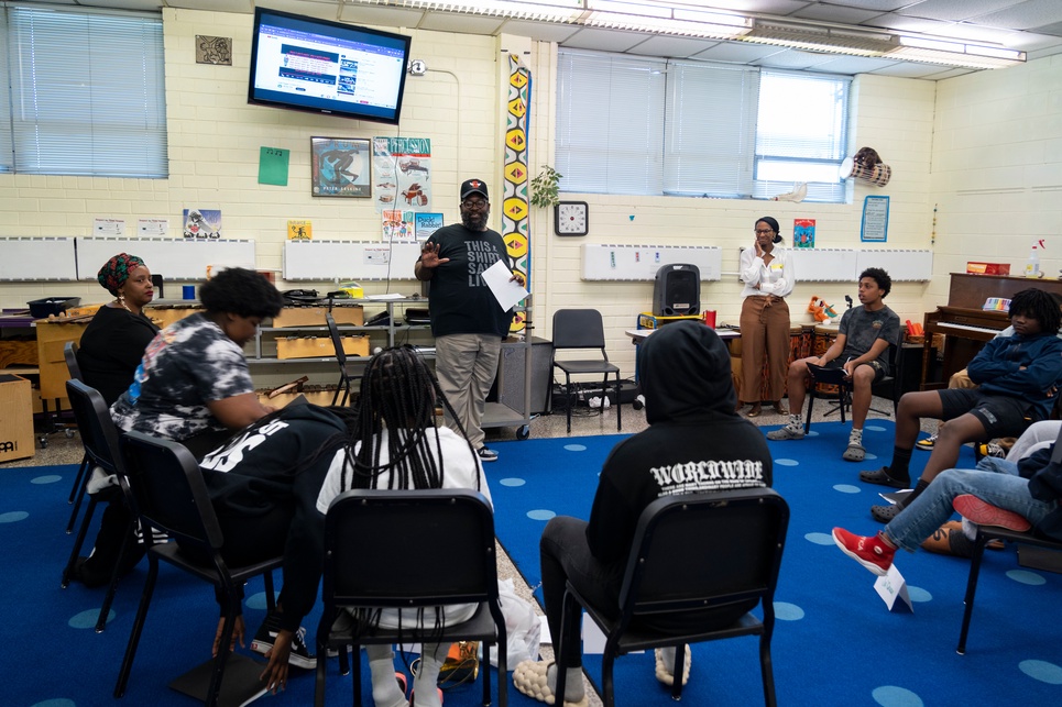 group of kids sitting in a circle around instructor