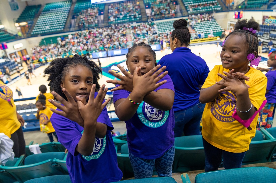 3 kids making uncw hawks with their hands