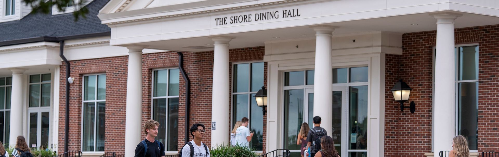 students walking in front of the shore dining hall on the first day of class
