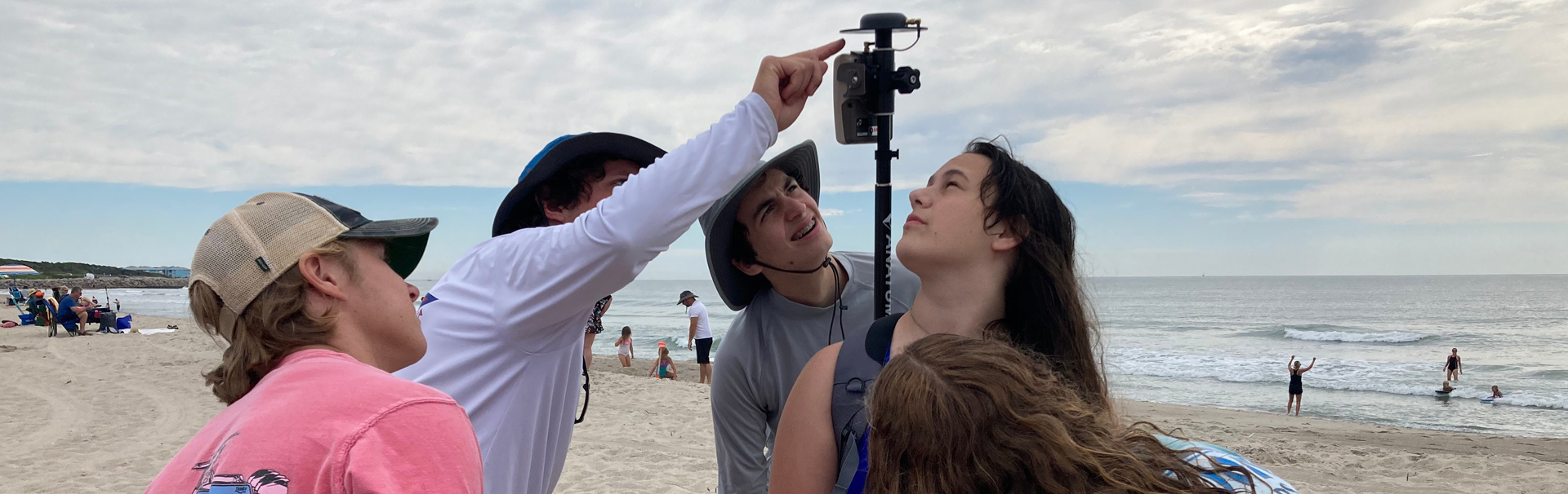 Students taking measurement on the beach
