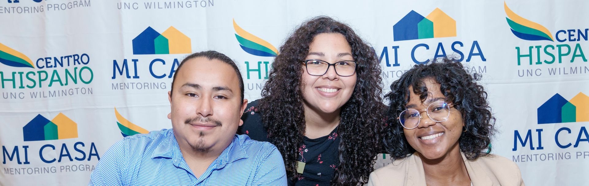 3 people pose for camera at business expo Impacto Latino