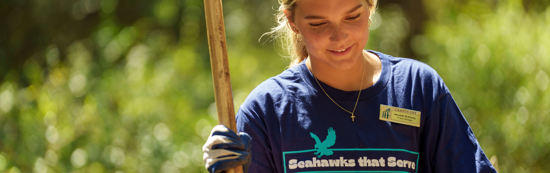 This is an image of a student gardening with the quote that we use when we talk about community engagement work.
