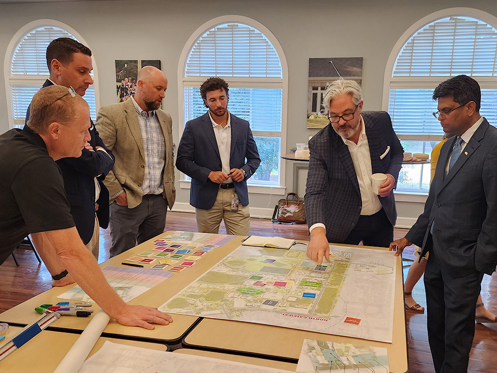 leadership discuss the masterplan around a table.